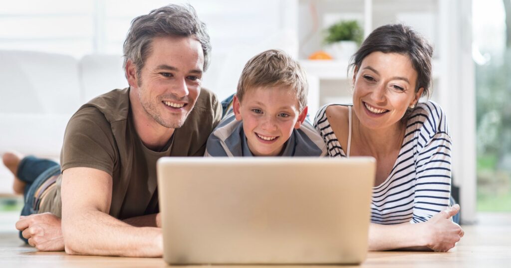 Família de pai, filho e mãe olhando tela de laptop