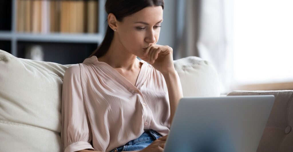 Mulher branca pesquisando no laptop sobre poupança ou conta corrente