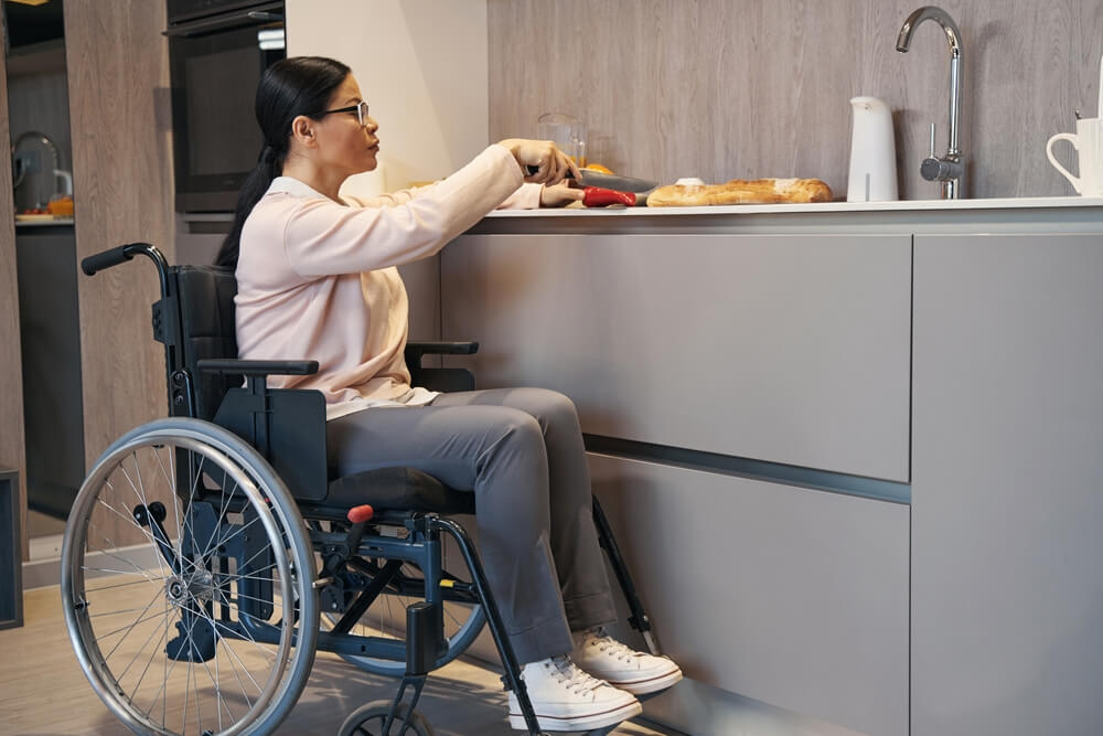 mulher na cadeira de rodas preparando a comida
