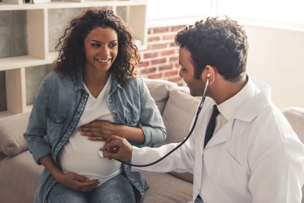 Mulher grávida consultando médico sobre parto normal ou cesárea